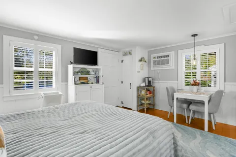 a bedroom with a bed and a flat tv screen on the dresser