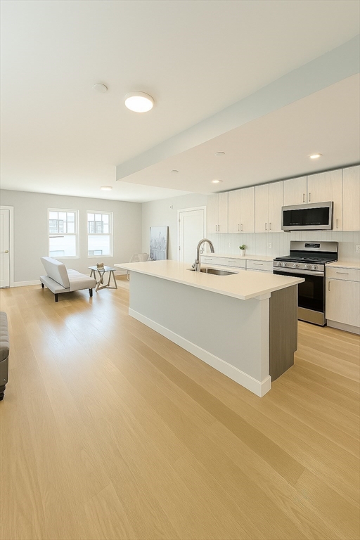 a kitchen with a sink cabinets and wooden floor