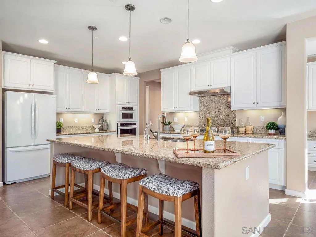 17568 Ralphs Ranch Road San Diego, CA 92127 - Photo 4 of 25 a kitchen with kitchen island granite countertop a table and chairs in it