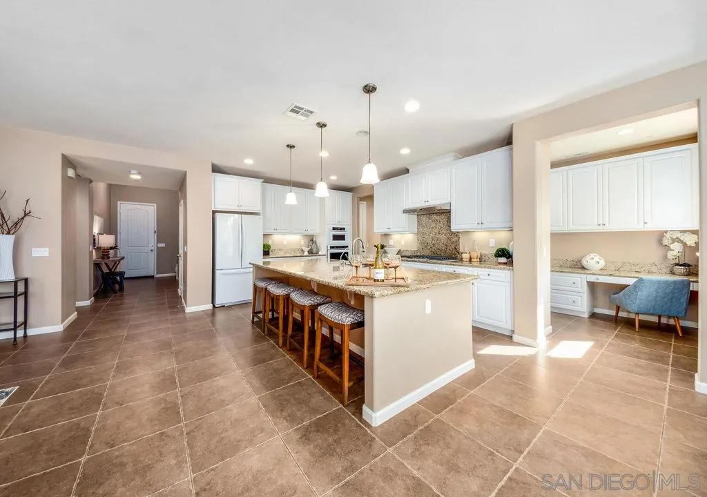 17568 Ralphs Ranch Road San Diego, CA 92127 - Photo 6 of 25 a large white kitchen with a large counter top and stainless steel appliances