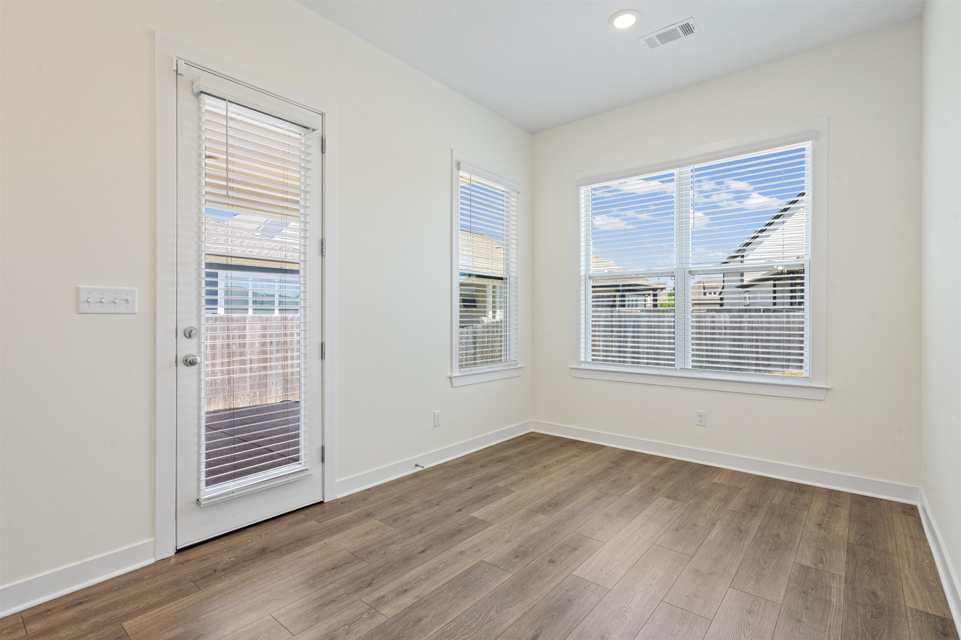 5666 Pleasant Pk Place Arlington, TN 38002 - Photo 17 of 27 Light-filled room featuring wood-finish flooring, white baseboards, and a glass-paneled door with integrated blinds