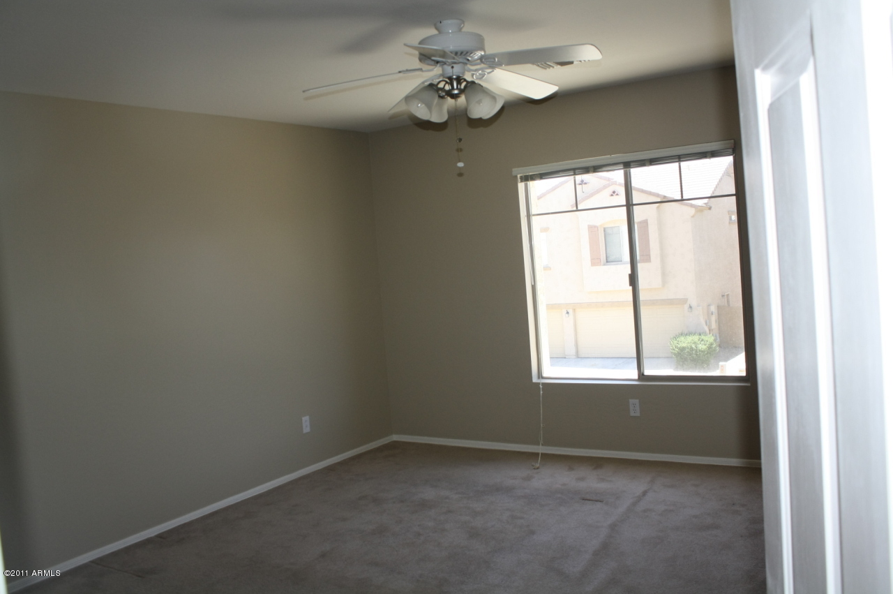 5114 West Apollo Road Laveen, AZ 85339 - Photo 17 of 17 an empty room with a window and a fan