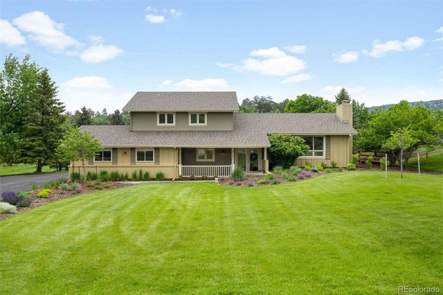 a view of a house with a big yard and sitting area