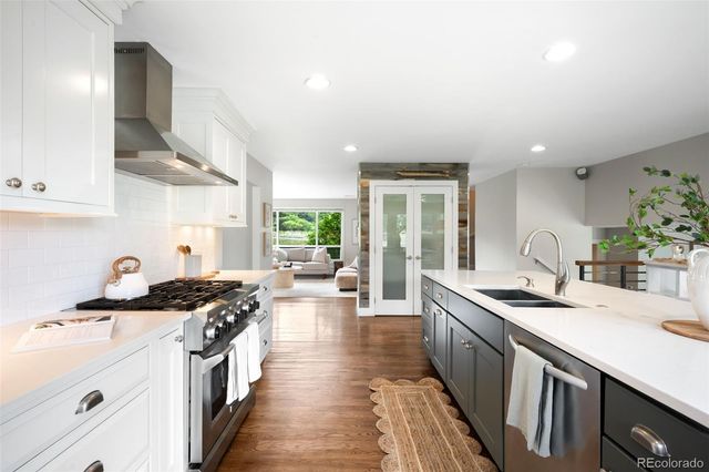 a kitchen with stainless steel appliances a sink stove and cabinets