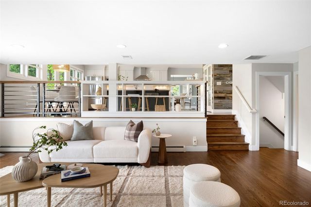 a living room with furniture and a wooden floor