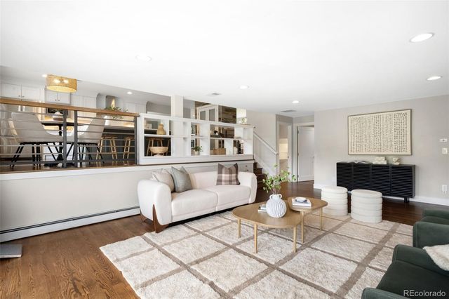 a living room with furniture a rug and white walls