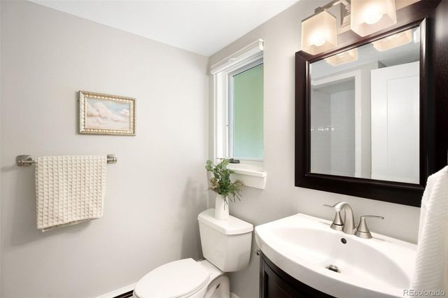 a bathroom with a toilet a sink and mirror