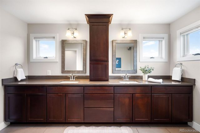 a bathroom with double vanity sinks and a mirror