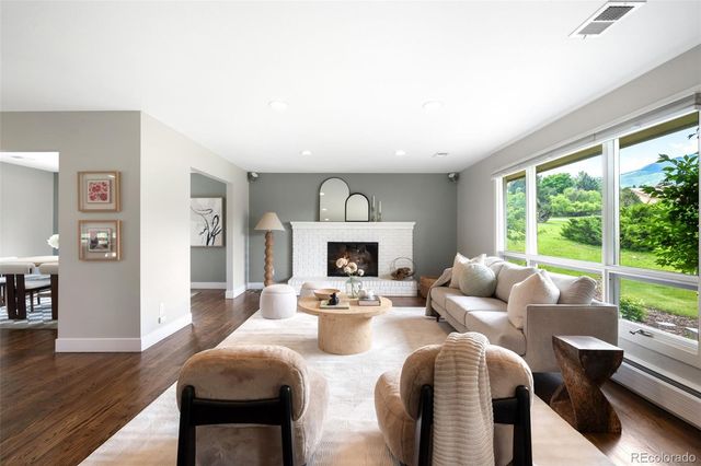 a living room with furniture fireplace and a large window