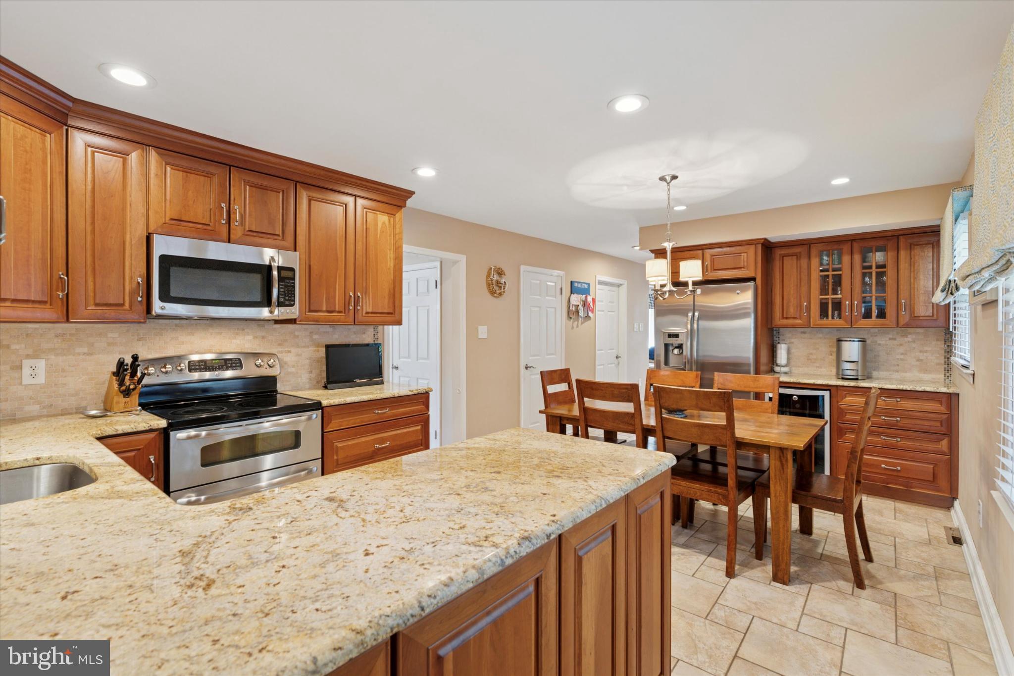 101 Rockland Road Havertown, PA 19083 - Photo 4 of 35 a kitchen with stainless steel appliances granite countertop a stove top oven a sink a dining table and chairs