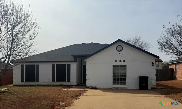 a front view of a house with a tree