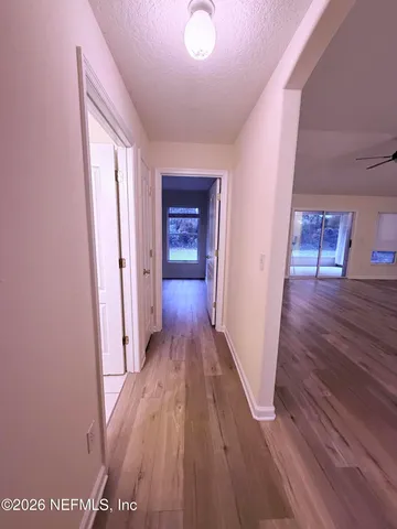 a view of a hallway with wooden floor
