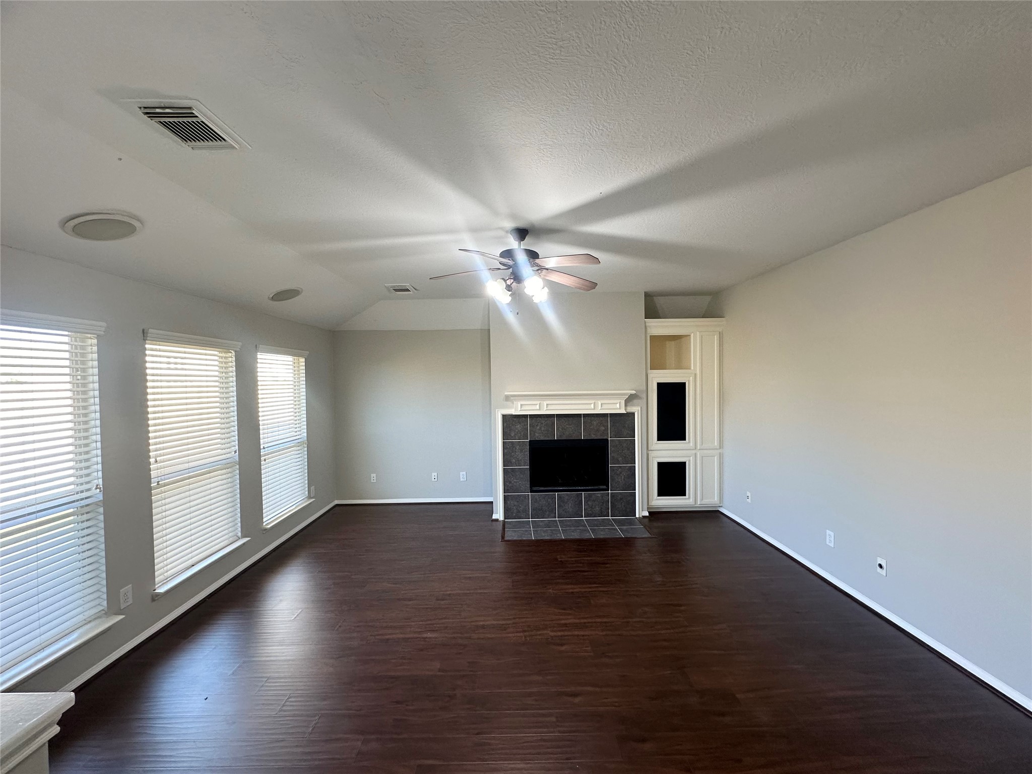 18822 Appletree Ridge Road Houston, TX 77084 - Photo 11 of 27 an empty room with windows fireplace and wooden floor