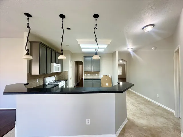 a kitchen with a counter top space appliances and a chandelier