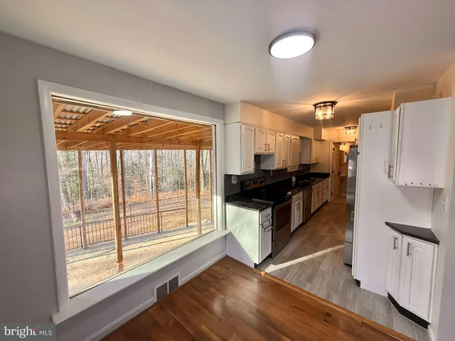a kitchen with granite countertop a refrigerator and wooden cabinets