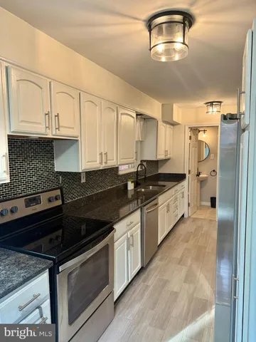 a kitchen with stainless steel appliances granite countertop a stove a sink and a refrigerator