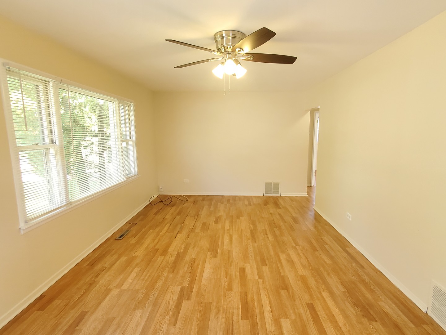 1657 Rice Street Waukegan, IL 60087 - Photo 3 of 10 a view of empty room with wooden floor and fan