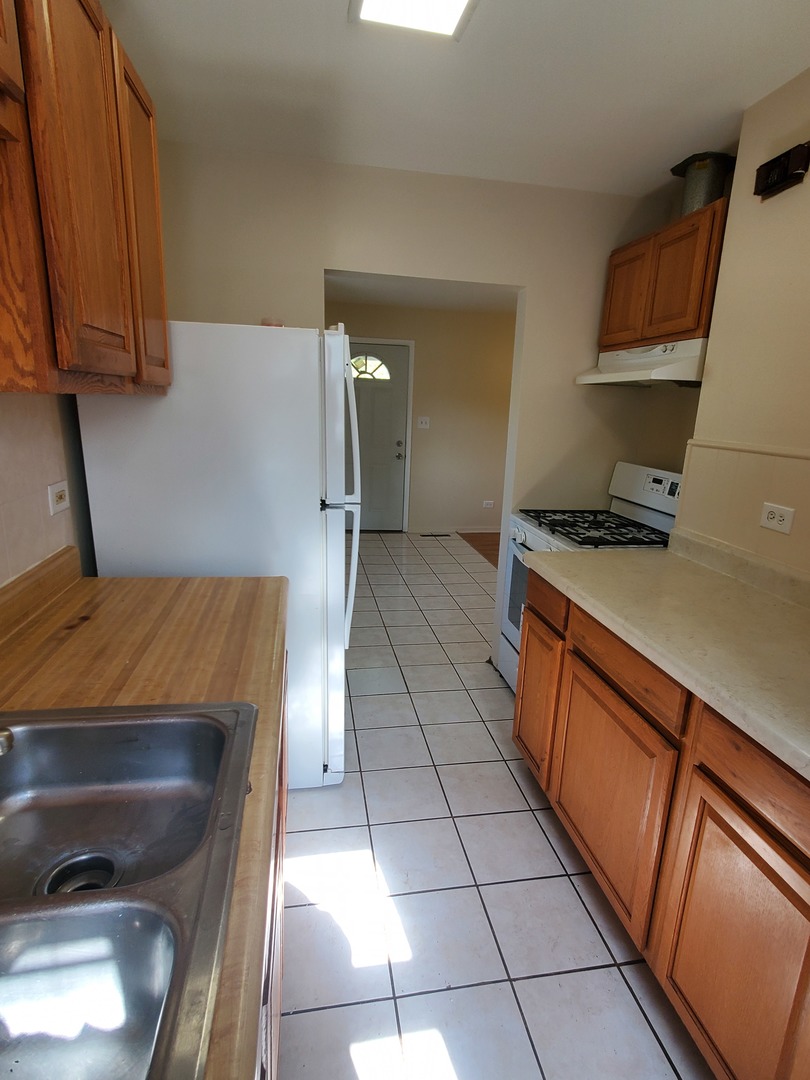 1657 Rice Street Waukegan, IL 60087 - Photo 8 of 10 a kitchen with a sink a stove and cabinets