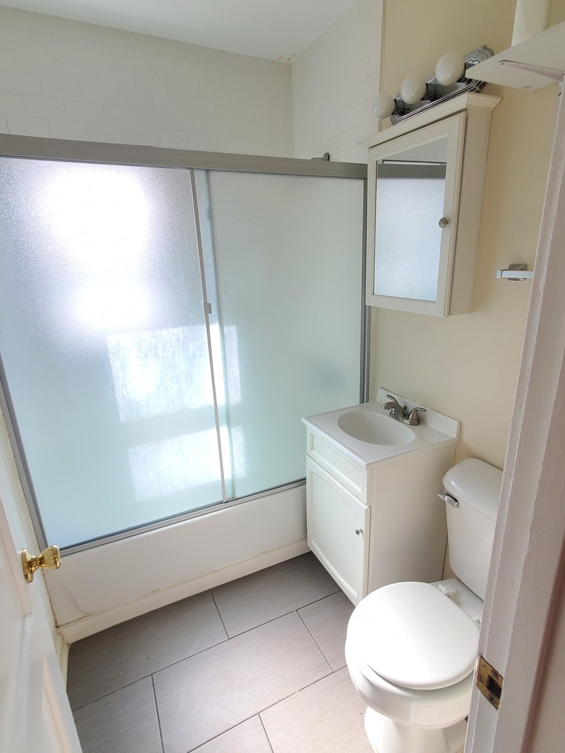 1657 Rice Street Waukegan, IL 60087 - Photo 9 of 10 a white toilet sitting next to a bathroom sink