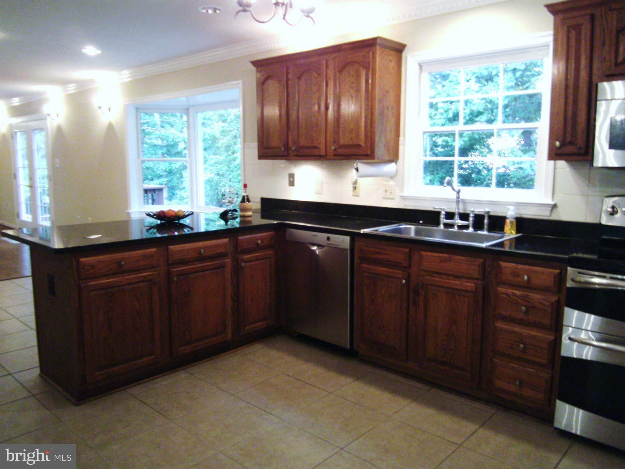 8662 Center Road Springfield, VA 22152 - Photo 5 of 23 a kitchen with stainless steel appliances granite countertop wooden cabinets a sink and a window