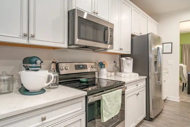 a kitchen with stainless steel appliances granite countertop a refrigerator stove top oven and sink