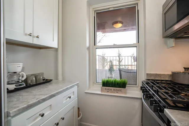 a kitchen with white cabinets and a stove