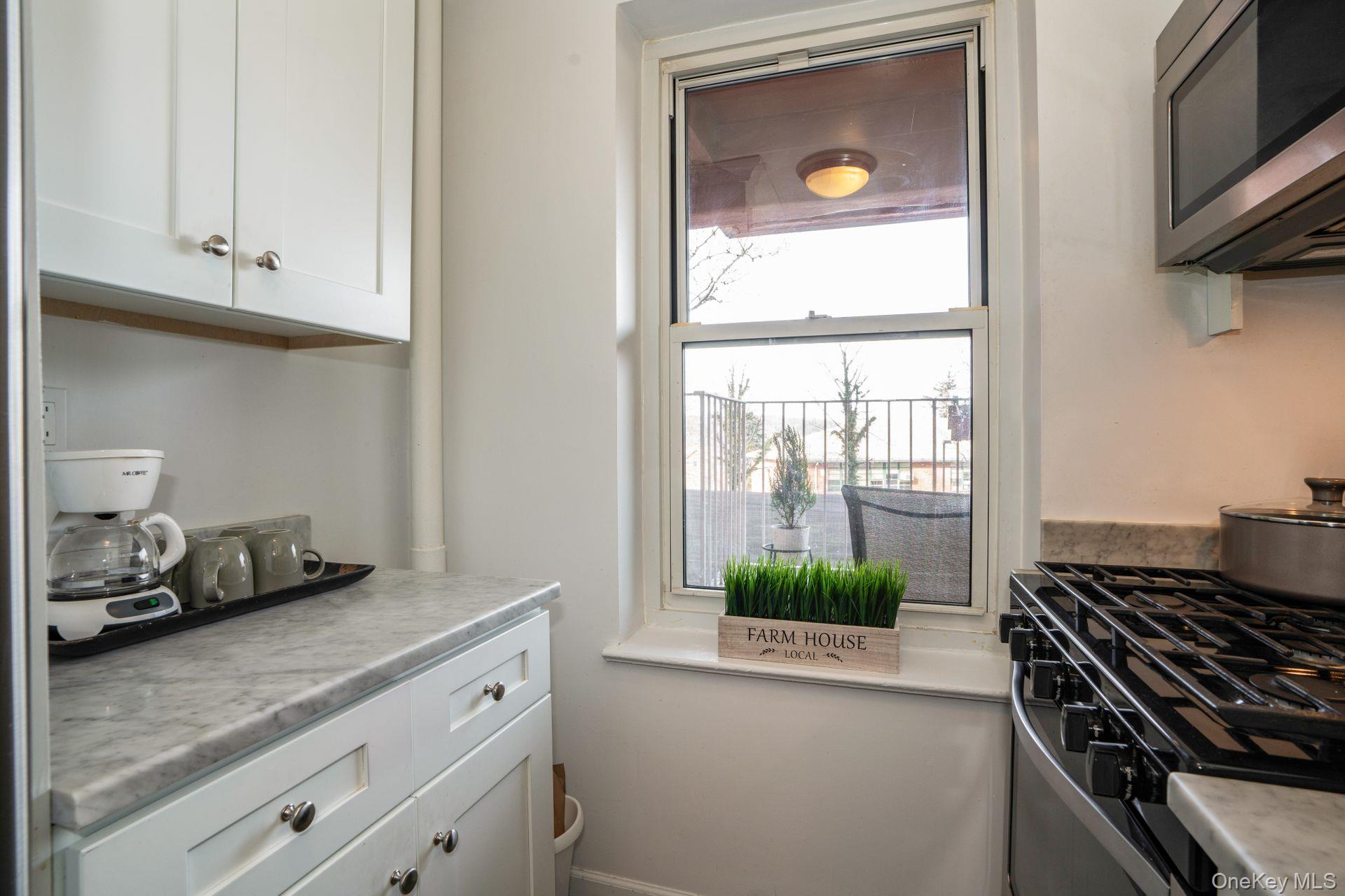 565 Broadway, Unit 1F Hastings-on-Hudson, NY 10706 - Photo 4 of 17 a kitchen with white cabinets and a stove