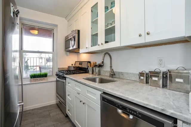 a kitchen with stainless steel appliances granite countertop a sink and a white cabinets