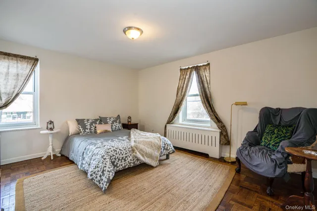 a bedroom with a bed windows and wooden floor