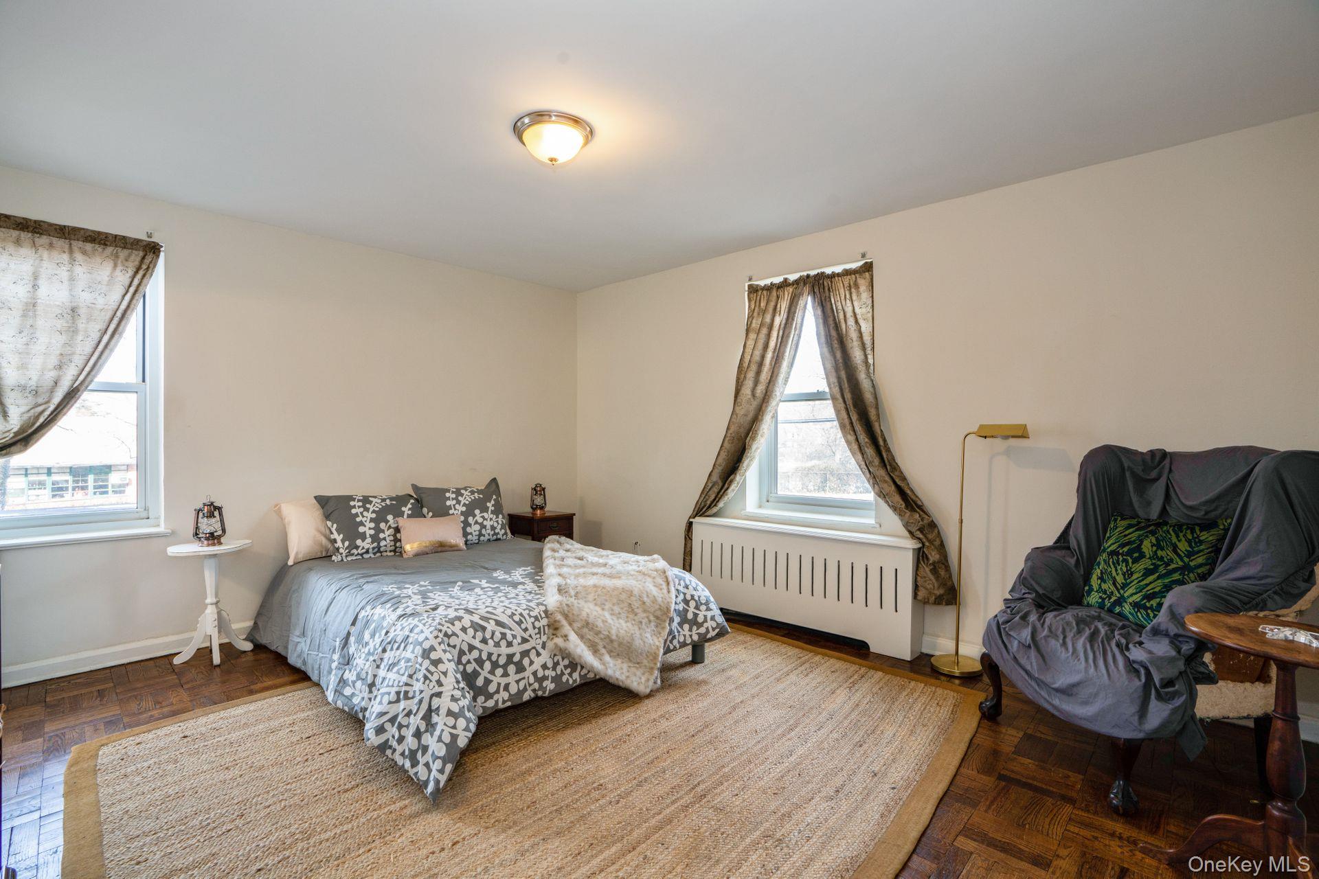 565 Broadway, Unit 1F Hastings-on-Hudson, NY 10706 - Photo 8 of 17 a bedroom with a bed windows and wooden floor