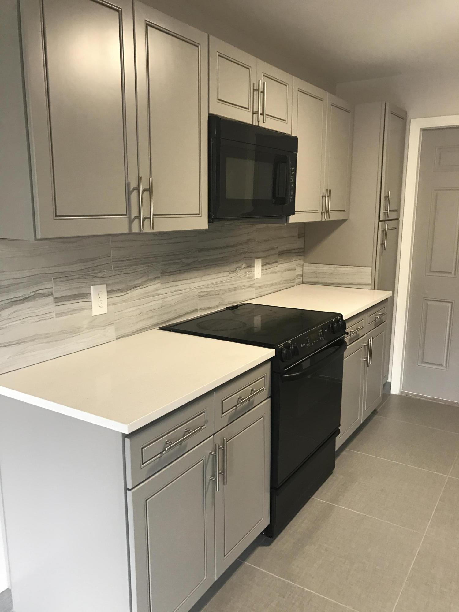 142 Southwest 8th Avenue, Unit B Delray Beach, FL 33444 - Photo 3 of 29 a kitchen with stainless steel appliances granite countertop a sink and a microwave