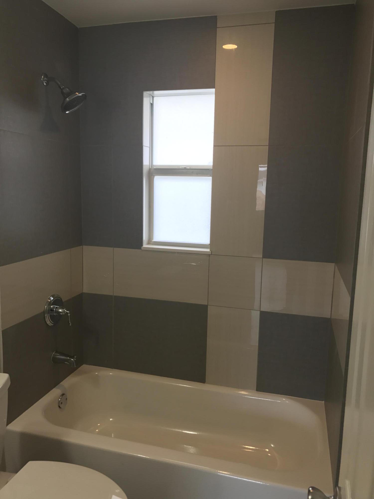 142 Southwest 8th Avenue, Unit B Delray Beach, FL 33444 - Photo 10 of 29 a bathroom with a bathtub and window