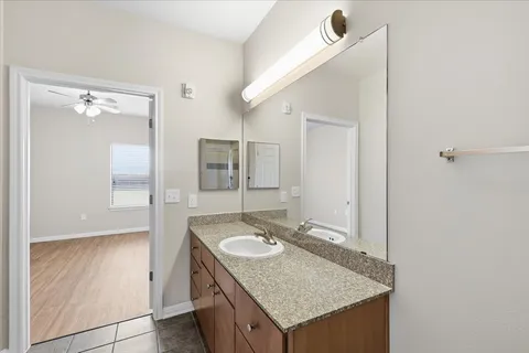 a bathroom with a granite countertop sink and a mirror
