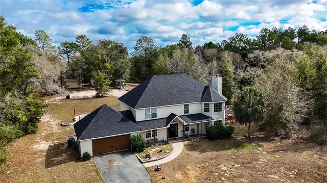 an aerial view of a house with swimming pool and sitting area