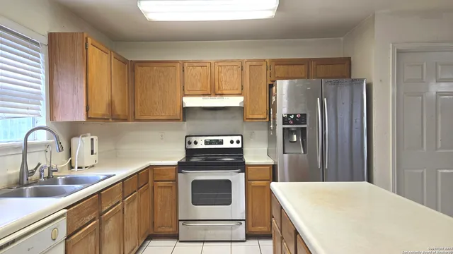 a kitchen with a refrigerator sink and cabinets