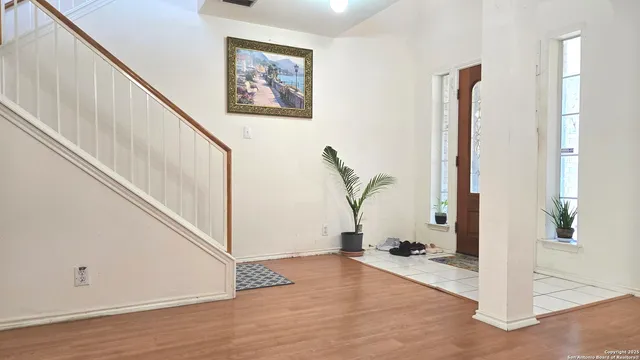 a view of a hallway with wooden floor and staircase