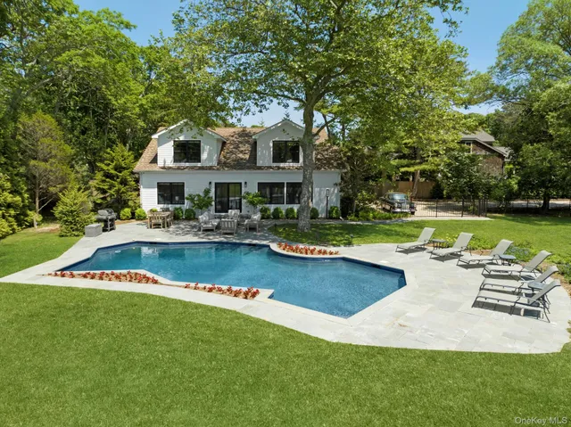 a view of a house with swimming pool and sitting area