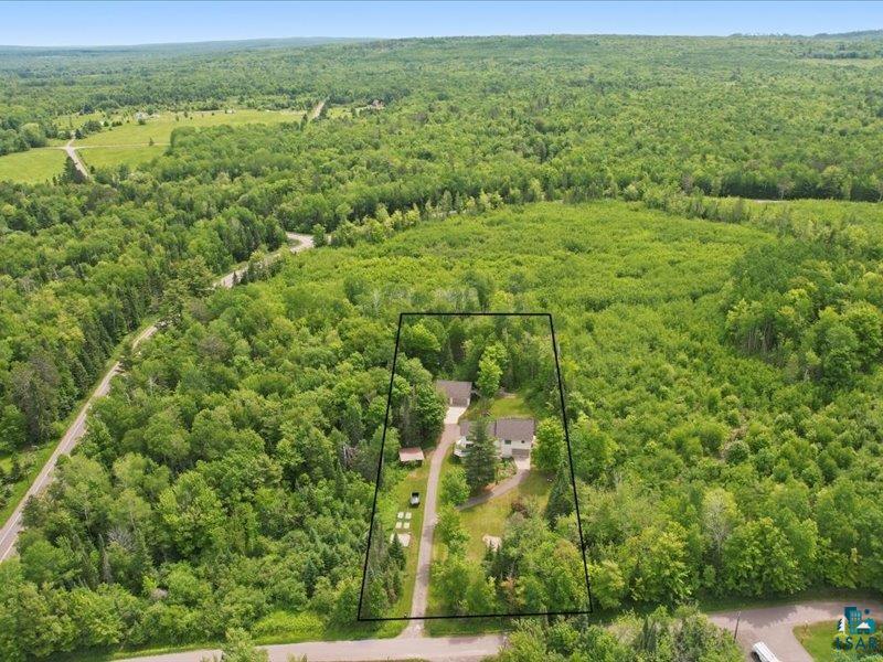 88440 Huron Street Cornucopia, WI 54827 - Photo 37 of 44 Aerial view facing South, showcasing residential structures surrounded by extensive mature trees & maple trees.