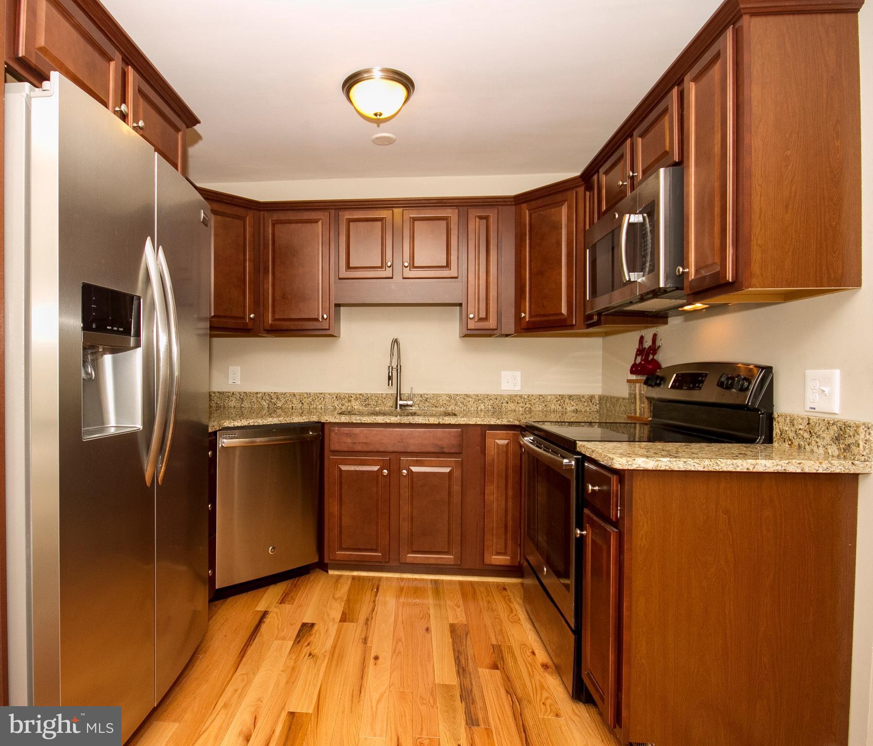 1618 Providence Road Towson, MD 21286 - Photo 13 of 30 a kitchen with stainless steel appliances granite countertop a refrigerator a sink dishwasher a stove with wooden cabinets and floor