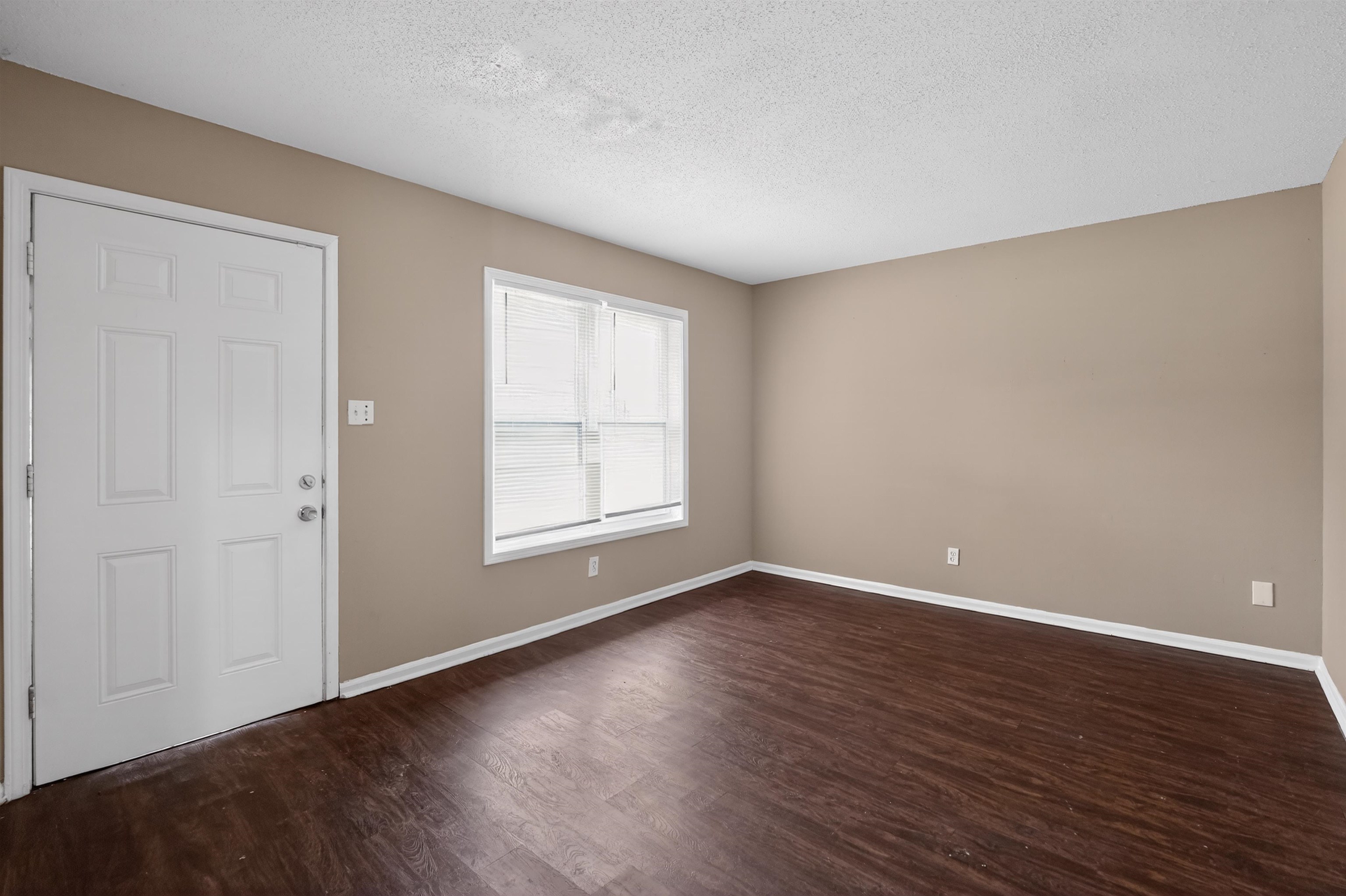 3608 Cane Ridge Drive Memphis, TN 38109 - Photo 13 of 31 Entry room featuring a paneled door, wood-finish flooring, neutral wall tones, and horizontal blinds