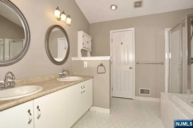 a bathroom with a granite countertop sink a mirror and a shower