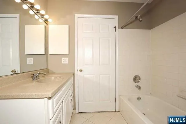 a bathroom with a tub sink and mirror