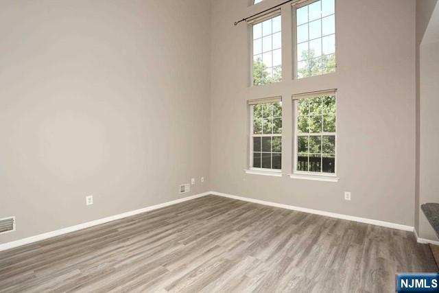 387 Green Mountain Road Mahwah, NJ 07430 - Photo 6 of 25 an empty room with wooden floor and windows