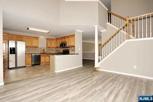 a view of kitchen with wooden floor and electronic appliances