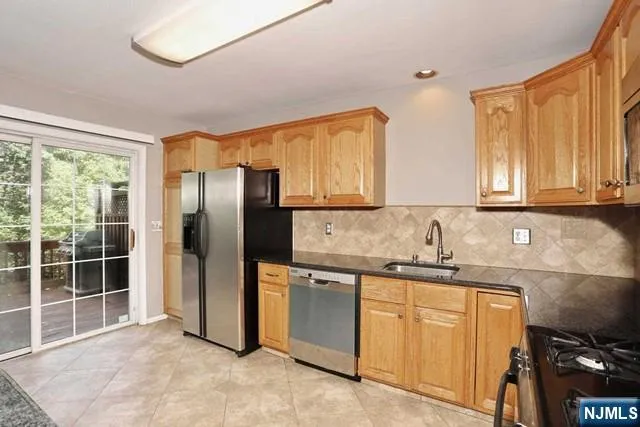 a kitchen with stainless steel appliances granite countertop a refrigerator and a sink