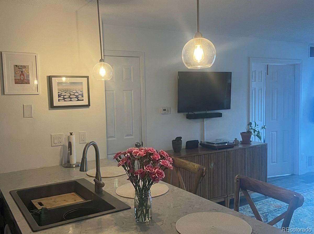 2575 South Syracuse Way, Unit D103 Denver, CO 80231 - Photo 5 of 10 a room with furniture and a flat screen tv