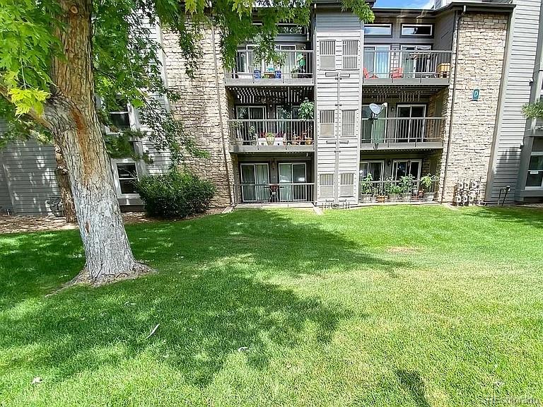 2575 South Syracuse Way, Unit D103 Denver, CO 80231 - Photo 6 of 10 a front view of a building with a garden