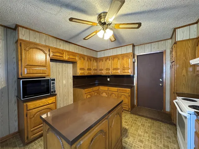 a kitchen with stainless steel appliances granite countertop a refrigerator a stove and a sink