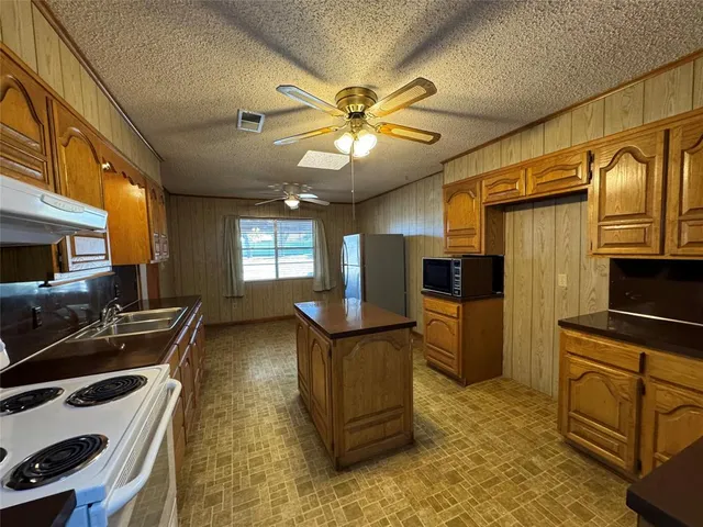 a kitchen with stainless steel appliances granite countertop a stove refrigerator and cabinets