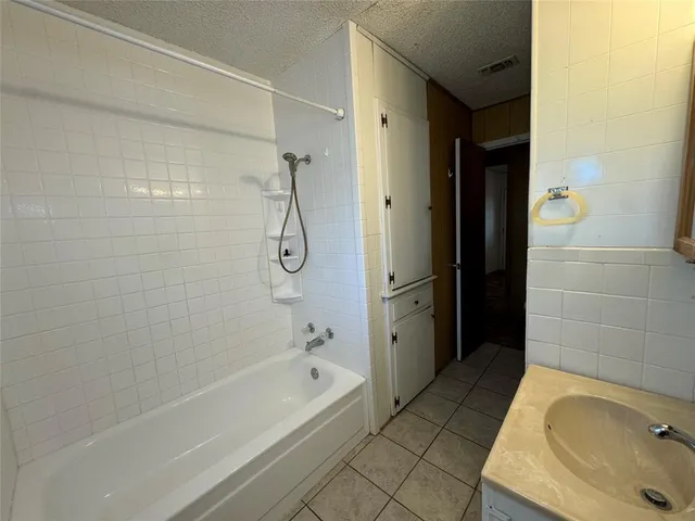 a bathroom with a tub a sink and a shower